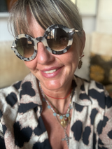 Lamusunglasses round frame sunglasses with a marbled tortoiseshell pattern and gradient lenses. Model wears them with a leopard print shirt.